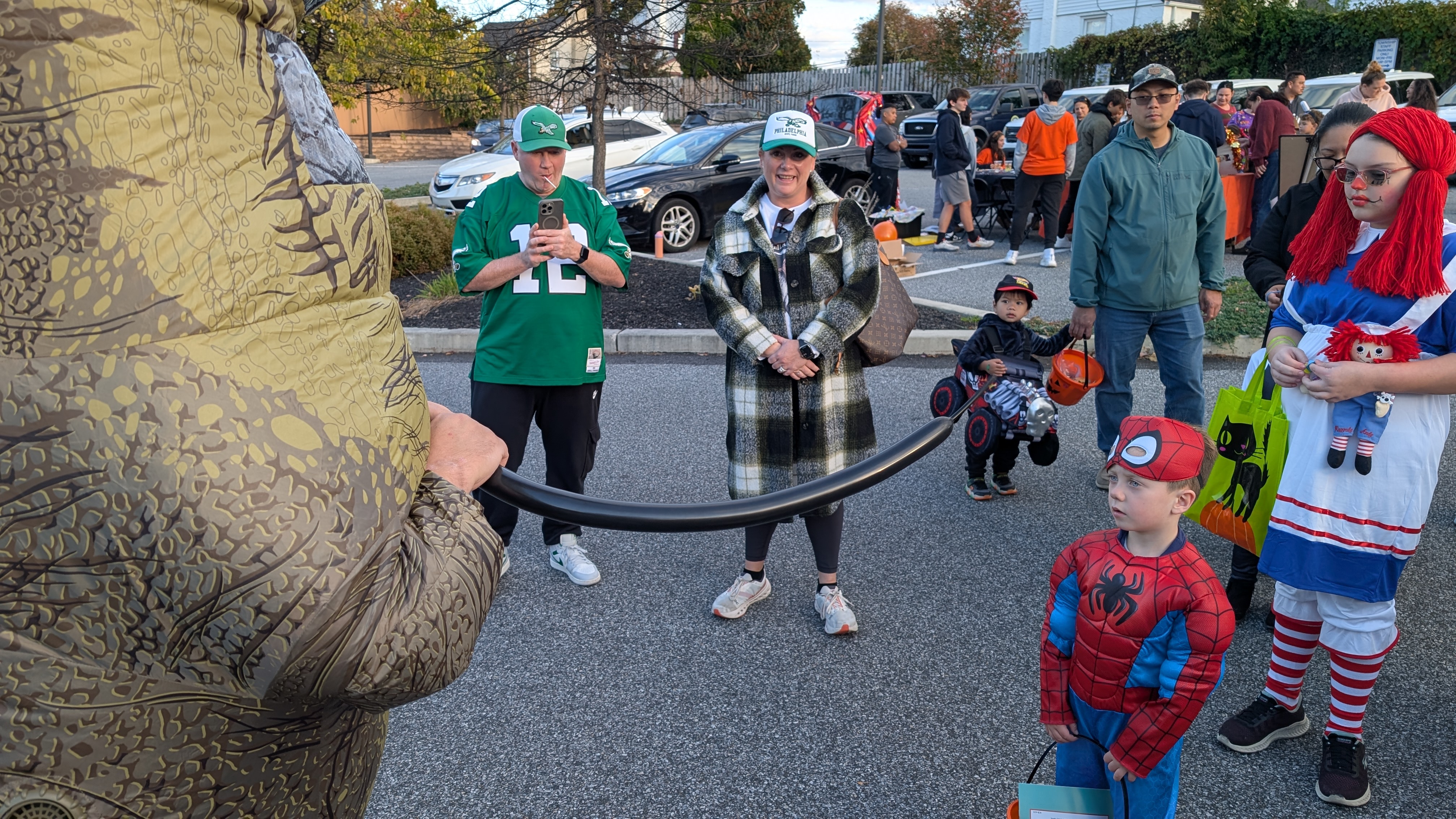 Handing a balloon sword to a Spiderman
